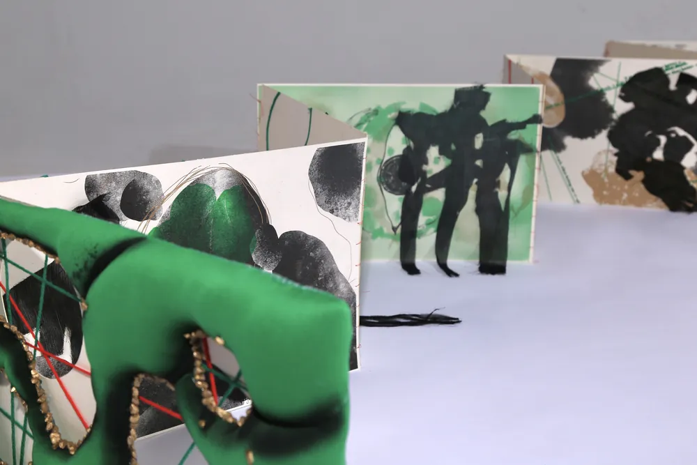 Folded pages with black brushed characters and green marks