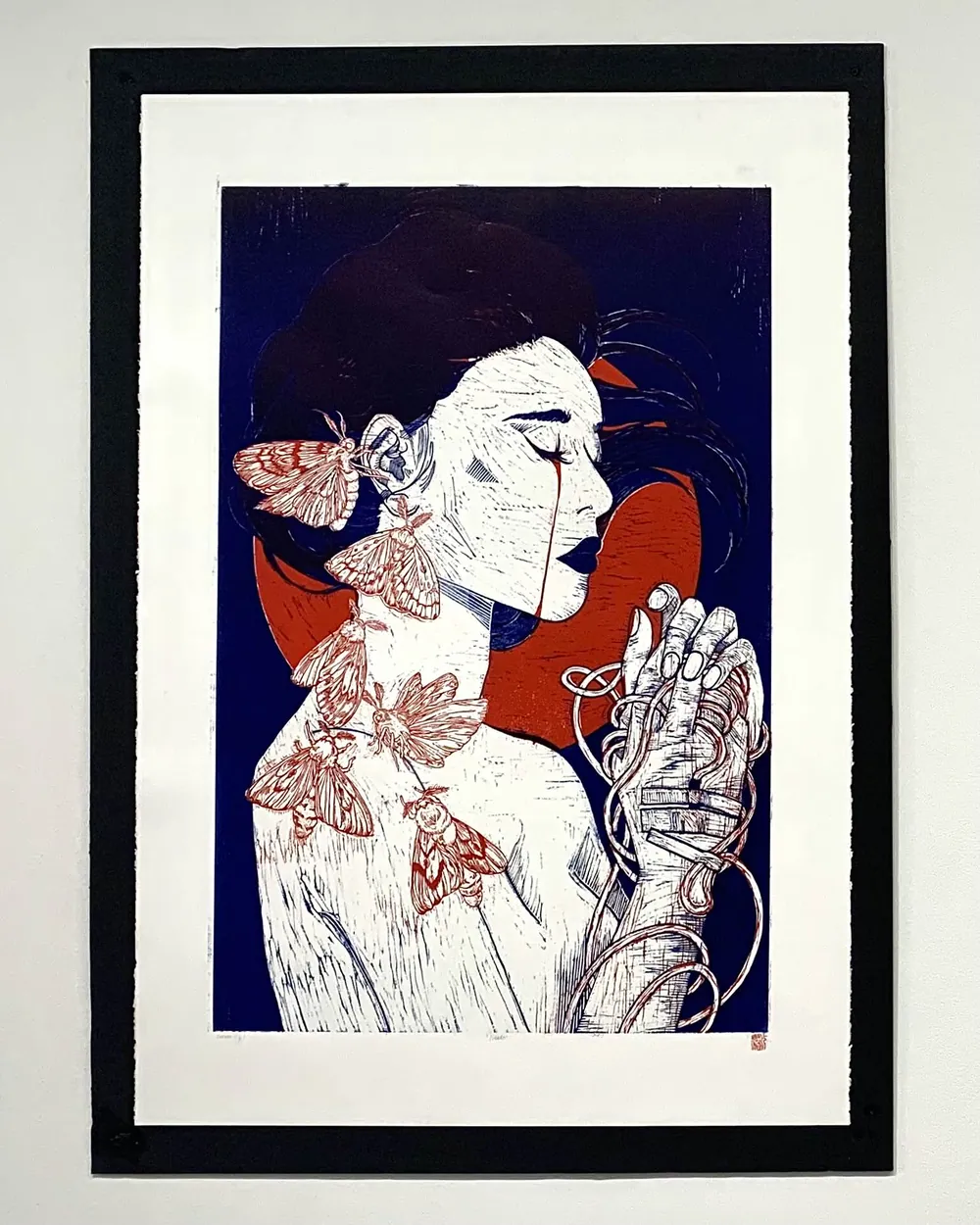 Needy: a framed multi-colour relief print of a figure with moths on the skin