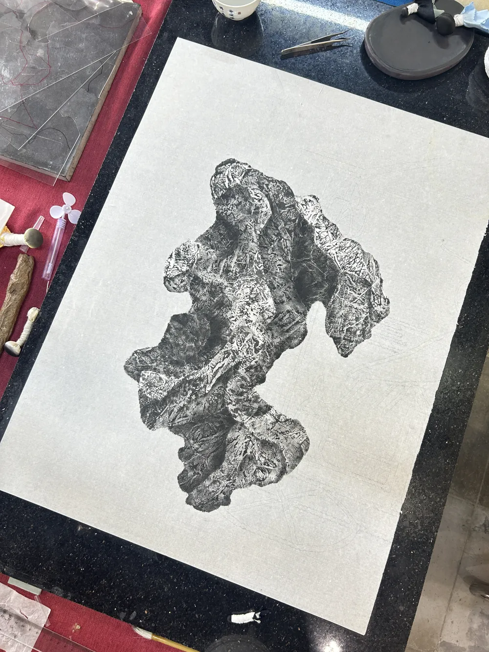 The rubbing laid out on the table among tools