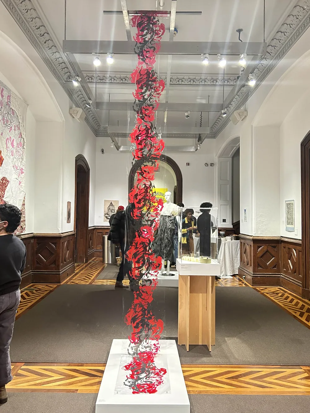 Spirit of Stone: a tall spine-like form screen-printed in red on clear acetate, hanging in a historic gallery
