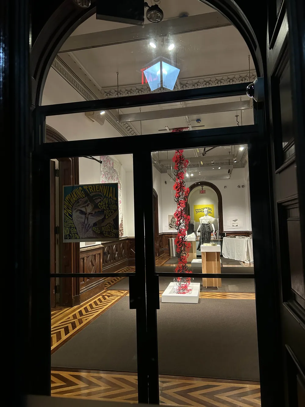 The installation seen through the gallery doorway at night